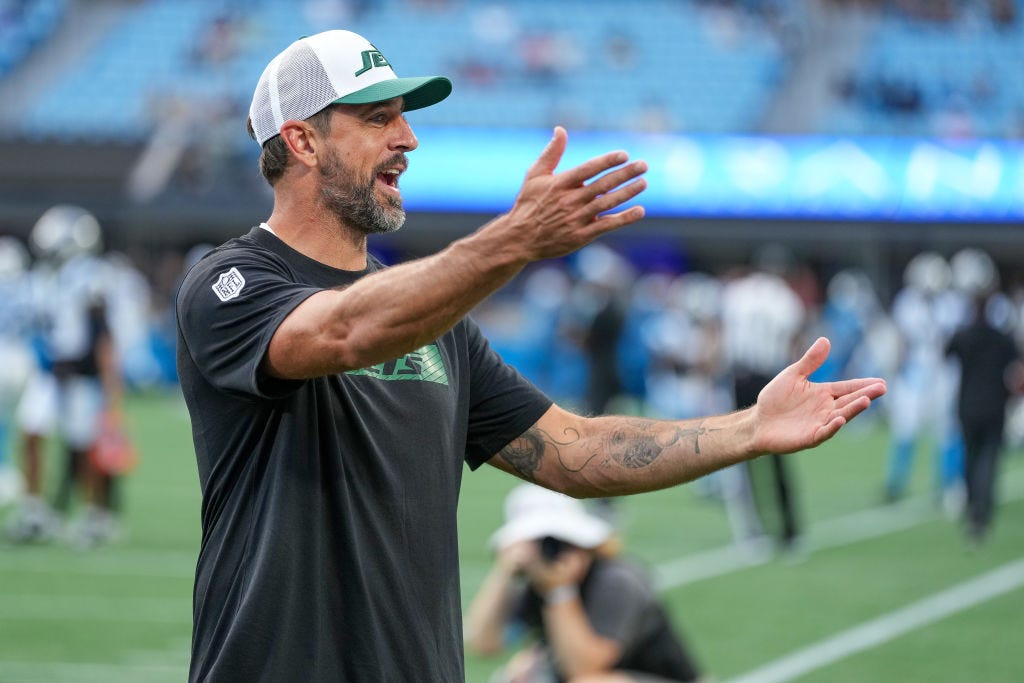  Aaron Rodgers #8 of the New York Jets jokes with fans before their preseason game against the Carolina Panthers at Bank of America Stadium on August 17, 2024 in Charlotte, North Carolina.