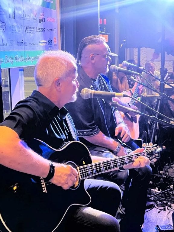 side view of a man playing a guitar and singing into a microphone as part of the southwest Florida weekend events