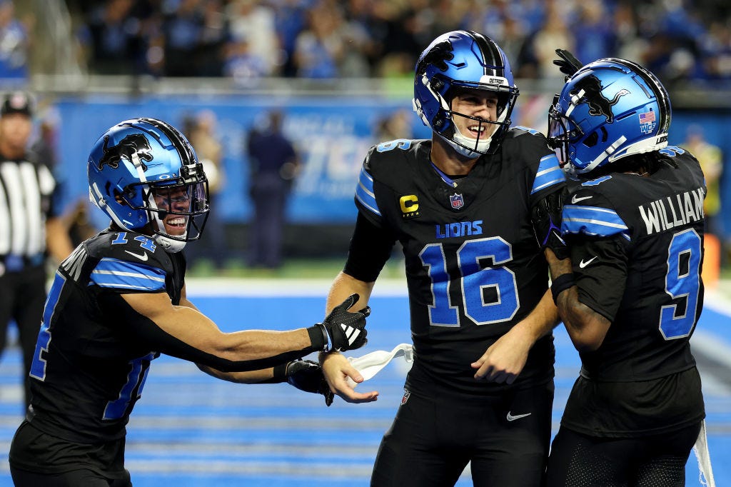 Jared Goff #16 of the Detroit Lions celebrates with Amon-Ra St. Brown #14 and Jameson Williams #9 after catching a touchdown pass against the Seattle Seahawks during the third quarter at Ford Field on September 30, 2024 in Detroit, Michigan. 